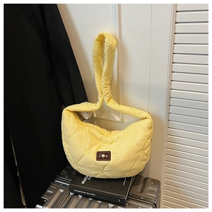 Détail du sac croissant jaune clair matelassé avec texture cœur et logo perle
