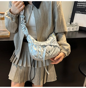Détail du sac à bandoulière plissé métallisé argenté avec nœud et sangle assortie