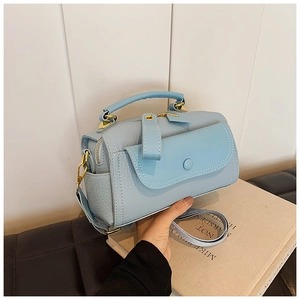 Dettaglio della borsa Boston azzurra in pelle a grana con hardware in metallo dorato