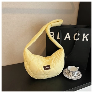 Vue détaillée du sac matelassé jaune vif avec motifs de cœurs et écusson en cuir