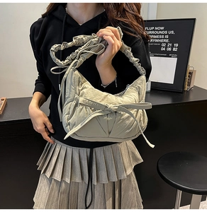 Détail du sac bandoulière plissé vert clair avec un grand nœud et une bandoulière nuage