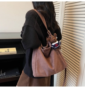 Détails du sac seau en daim marron avec un pendentif d'ours en peluche mignon