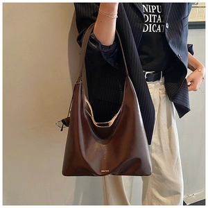 Detail of dark brown leather hobo bag with Chlo'me logo and elegant shoulder strap