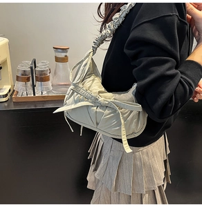 Détail du sac bandoulière plissé vert clair avec grand nœud et bandoulière nuage