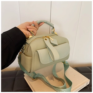 Dettaglio della borsa in pelle verde chiaro a grana con hardware in metallo dorato