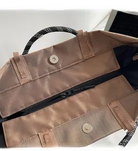 Detail of waterproof khaki tote showing the black zipper and silver magnetic hardware buckles