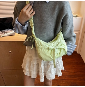 Détail du sac à bandoulière plissé vert avec nœud et bandoulière froncée élégante