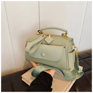 Dettaglio borsa verde menta con grana martellata, finiture dorate e tracolla larga
