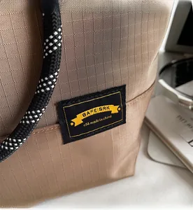 Close-up of brown ripstop nylon tote bag featuring texture detail and rope shoulder strap