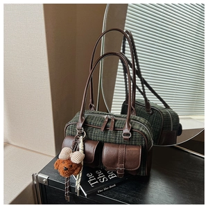 Détail du sac à bandoulière vintage à carreaux avec finitions cuir et breloque ours