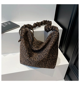 Detail of leopard print hobo bag showing scrunchie shoulder strap and metal zipper