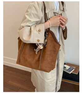 Brown suede tote bag detail with cute animal charm and spacious interior for daily use