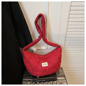 Détail du sac rouge matelassé avec broderie en cœur et étiquette de marque tissée