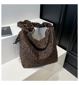 Detail view of leopard print tote bag with ruched shoulder strap and metal zipper closure