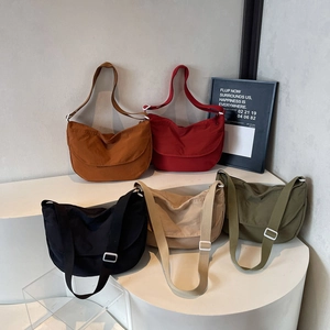 Minimalist canvas dumpling cross-body bags displayed in five trendy solid colors