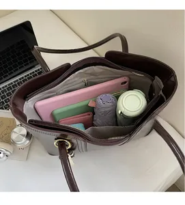 Macro detail of spacious brown leather tote interior with daily essentials and tablet