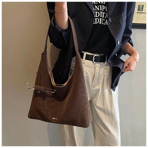 Detail view of large dark brown hobo tote bag featuring unique glasses holder strap