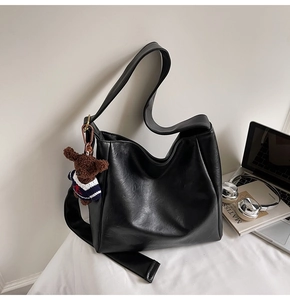 Gros plan du sac seau noir mat avec un joli petit pendentif ours brun attaché