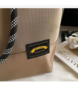Detail of tear-resistant grid fabric and sturdy rope handle on this brown tote bag