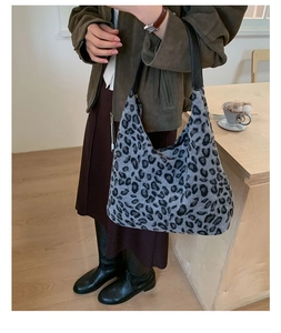 Détail du sac hobo en peluche léopard montrant la maille douce et la bandoulière en cuir