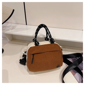 Detail of brown corduroy and white leather contrast bag with rope handles and wide strap