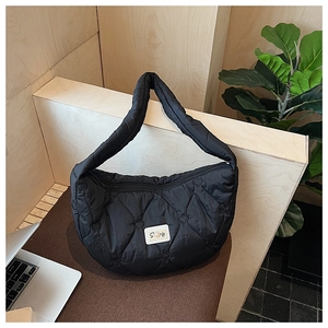 Vue détaillée d'un sac demi-lune noir matelassé présentant des motifs de cœurs brodés