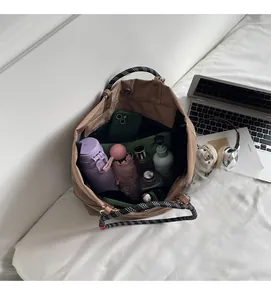 Detailed view of the spacious nylon tote bag interior with braided handles and inner pocket