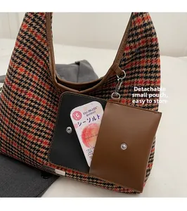 Detail of wool houndstooth shoulder bag featuring a detachable mini pouch and leather trim