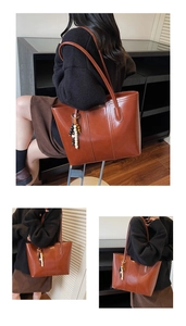 Detail of vintage brown tote bag with beaded tassel and soft synthetic leather texture