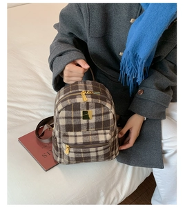 Close-up of winter plaid tweed mini backpack with gold hardware and textured fabric details