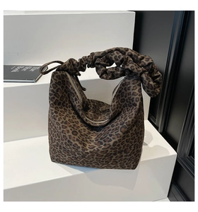 Detail of leopard print tote bag featuring a creative ruched handle and smooth zipper closure