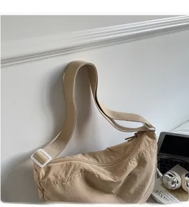 Detail of khaki nylon crescent bag with wide adjustable shoulder strap and smooth zipper