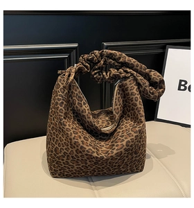 Detail shot of leopard print shoulder bag with ruched handles and silver metal zipper