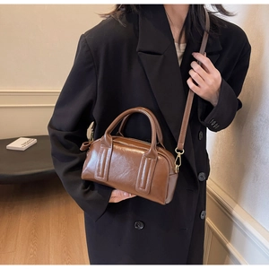 Dettaglio della borsa Boston in pelle lucida marrone con fibbie in metallo dorato