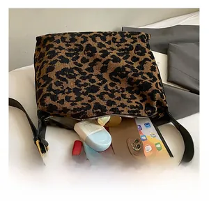 Macro view of leopard print suede bag interior showing high capacity for tablets and cosmetics