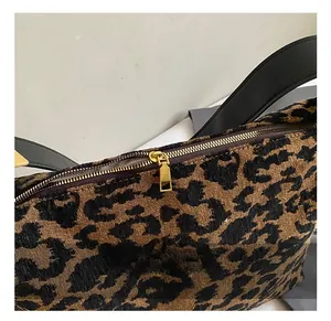 Detail of premium leopard print suede bag showing the golden metal zipper and black leather strap
