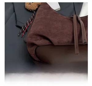 Detail shot of precise stitching on dark brown suede and smooth leather tote bag base