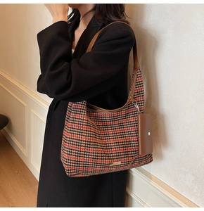 Detail view of houndstooth wool hobo bag with mini charm pouch and leather strap