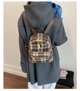 Winter plaid mini backpack in brown tweed shown on model with a grey woolen coat