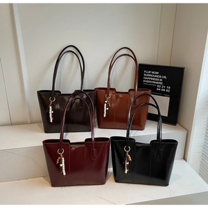 Detail showing four minimalist tote bags in dark brown, caramel, burgundy and black