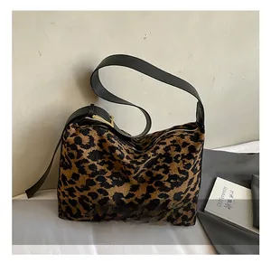 Detail of leopard print suede bag with premium black leather strap and gold buckle