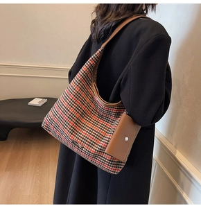 Detail of wool fabric plaid tote bag with brown leather strap and small coin purse