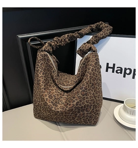 Close-up of leopard print tote bag featuring ruched handle and silver metal zipper detail