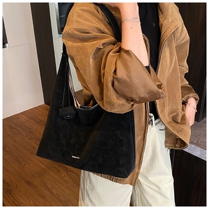 Close-up of black matte hobo bag with high-quality suede texture and minimalist metal logo