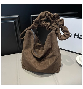 Detailed view of the ruffled handle design and premium brown suede texture of the tote bag