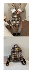 Detail view of mini plaid backpack with gold hardware and warm winter fabric texture