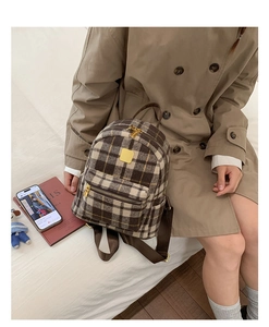 Detail of plaid backpack showing the high-quality woolen fabric and golden metal zippers