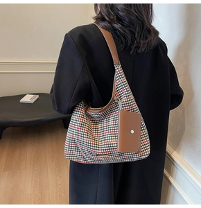Houndstooth shoulder bag with leather trim shown on a model in a modern interior