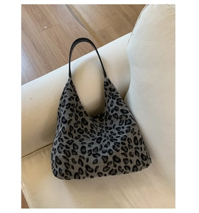 Gros plan du sac bandoulière en peluche léopard sur canapé montrant la texture