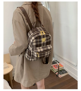 Close-up of winter plaid backpack featuring classic wool checkered pattern and gold zippers